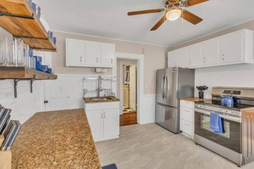 a kitchen with white cabinets and a ceiling fan at Classic West Hartford Center Apartment in West Hartford