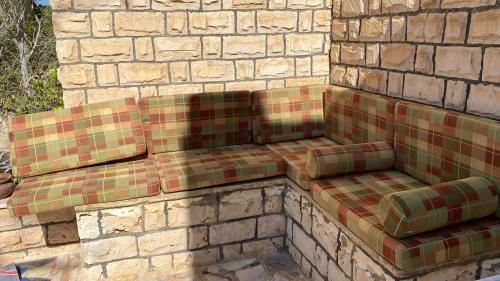 a couch sitting on the side of a brick wall at فيلا في قريه الصحفيين in El Alamein