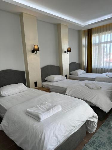 a hotel room with three beds with towels on them at Medi Otel in Samsun