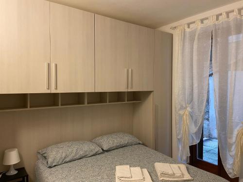 una camera con letto, armadi e finestra di Bilocale L' Antica Corte ad Appiano Gentile