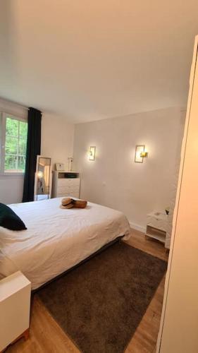 une chambre avec un grand lit blanc et une fenêtre dans l'établissement Maison Confortable en forêt près des plages Aucun voisinage, à Saint-Pierre-dʼOléron