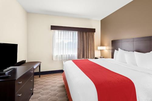 a hotel room with a large bed and a television at Best Western Palmyra Inn & Suites in Palmyra