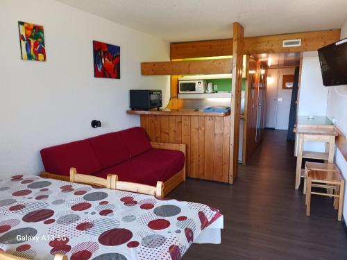 un salon avec un canapé rouge et une cuisine dans l'établissement Studio confortable pour 5 personnes avec WiFi et animaux admis, proche des pistes à Arc 1800 - FR-1-411-284, à Arc 1800