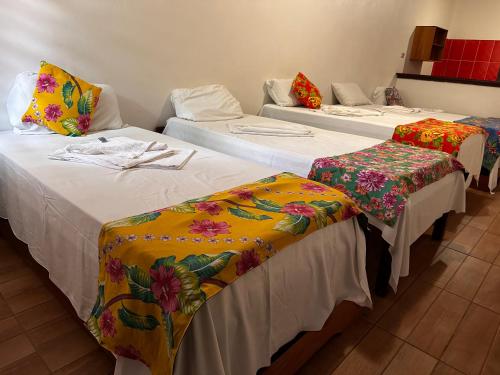 a group of three beds in a room at Hotel La Villa Morena in Oiapoque