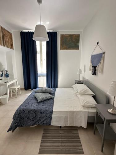 a bedroom with a large bed with blue curtains at Clarissa Guest House via di Mezzo 194 in Rieti