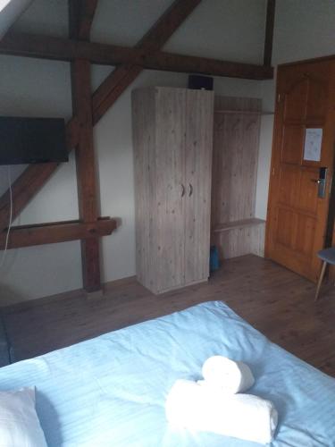 a bedroom with a bed with two towels on it at Kenguru Panzió és Csárda in Hódmezővásárhely