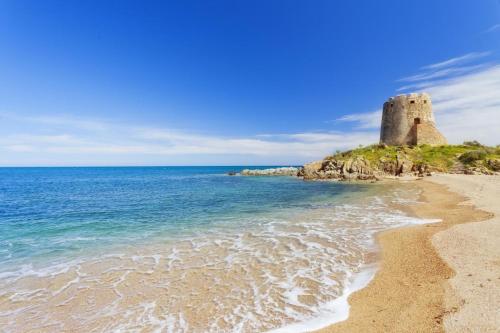 a view of a beach with a castle in the background at Sea Breeze Home in Lotzorai