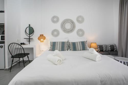 a white bed with two pillows on top of it at Calma Luxury Studios & Suites in Faliraki