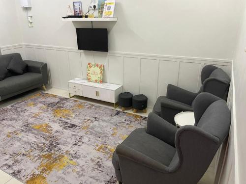 a living room with two chairs and a couch at Dania Homestay PD in Port Dickson