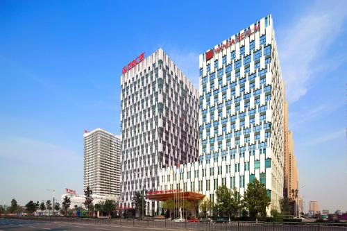 a tall building with a sign on top of it at Anyang Wanda Realm Hotel in Anyang