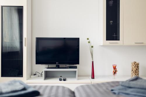 a living room with a tv on a white wall at Apartman Marija Ilok in Ilok