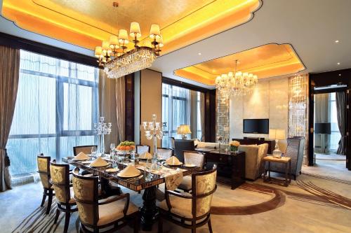 a dining room with a table and a living room at Anyang Wanda Realm Hotel in Anyang