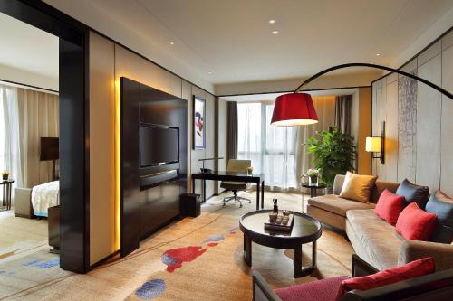 a living room with a couch and a television at Anyang Wanda Realm Hotel in Anyang