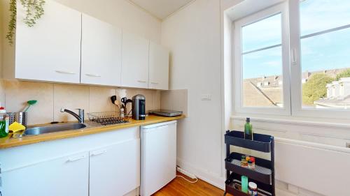 une cuisine avec des armoires blanches et une fenêtre dans l'établissement Le Studio Diamant, à Mulhouse