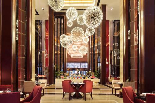 a restaurant with tables and chairs and a chandelier at Anyang Wanda Realm Hotel in Anyang