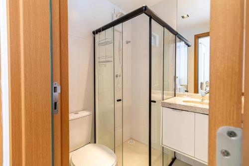 ein Badezimmer mit Toilette und Glasdusche in der Unterkunft Refúgio Tropical no San Martin - Destino BSM 203 A in Barra de São Miguel