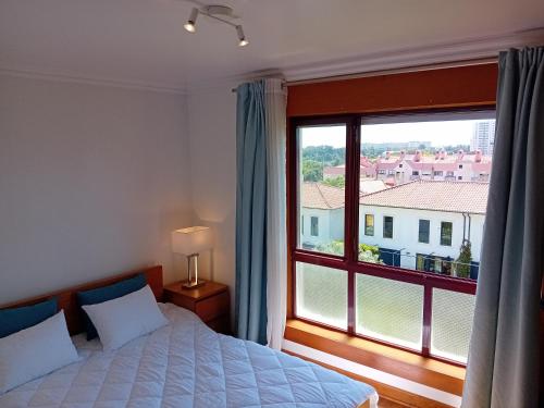 a bedroom with a bed and a large window at Lisbon Blue - Metro at your Door in Lisbon