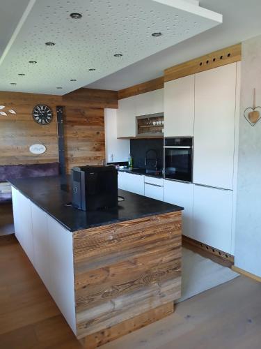 a kitchen with white cabinets and a black counter top at Ferienwohnung Anita in Umhausen