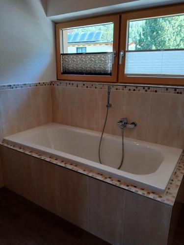 a bath tub in a bathroom with two windows at Ferienwohnung Anita in Umhausen