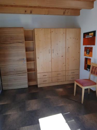 a room with wooden cabinets and a red chair at Ferienwohnung Anita in Umhausen