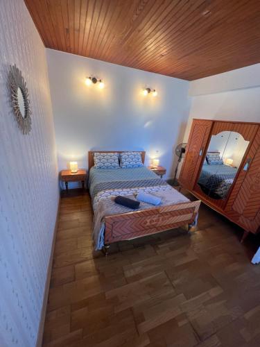 une chambre avec un lit et un miroir au mur dans l'établissement Gîte le clos, à Saint-Sulpice-de-Faleyrens