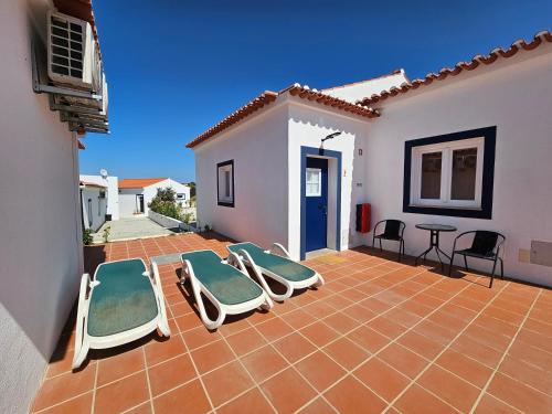 a patio with four lounge chairs and a table at Herdadinha in Vimieiro