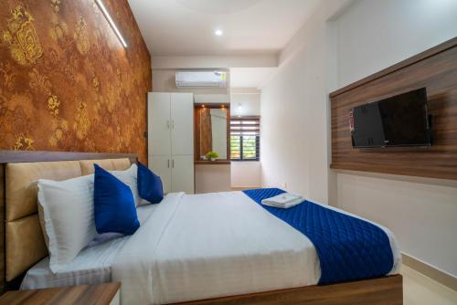 a bedroom with a large bed and a flat screen tv at Amala Arcade AC Rooms in Trichūr