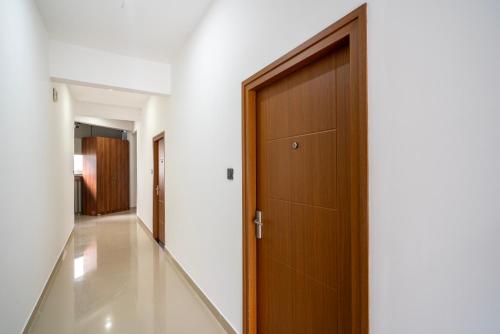 a hallway with a wooden door in a house at Amala Arcade AC Rooms in Trichūr
