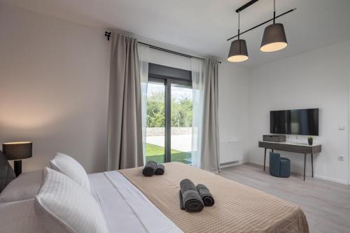 a bedroom with a bed with two slippers on it at Villa BB Rapsody 10 with heated salt water pool in Butkovići