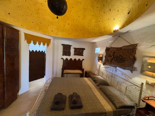 a bedroom with a large bed with a yellow ceiling at Case d'Artista in Savelletri di Fasano