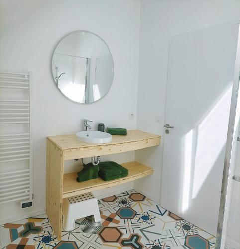 une salle de bain avec un lavabo et un miroir dans l'établissement Les Epinettes, à Pléneuf-Val-André