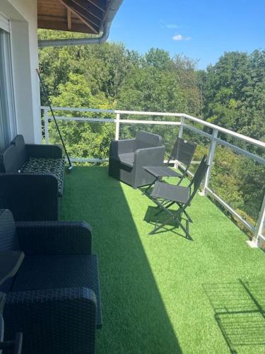 d'un balcon avec des chaises, des tables et une balustrade. dans l'établissement Havre de paix à 15 minute de Genève Calme et nature pour se ressourcer, à Péron