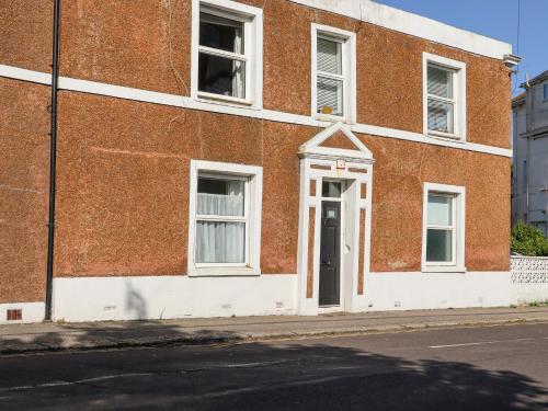 a red brick building with a door on a street at Goldhurst Apartment in Hastings