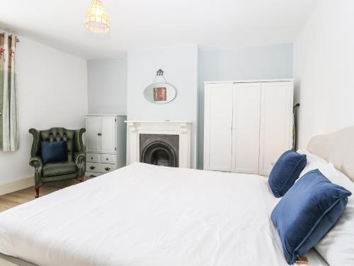 a bedroom with a large white bed and a chair at Goldhurst Apartment in Hastings