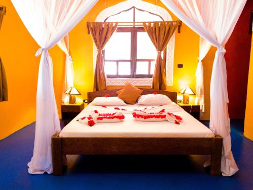 a bedroom with a bed with red decorations on it at Swahili Palace Zanzibar in Pwani Mchangani