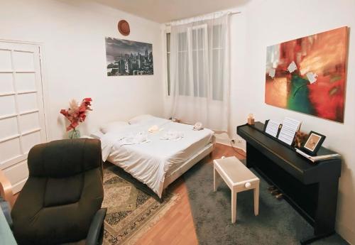 - une chambre avec un lit, une chaise et un piano dans l'établissement Fontaine, à Paris