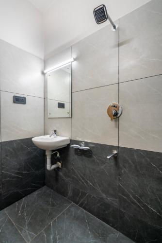 a bathroom with a sink and a mirror at Amala Arcade AC Rooms in Trichūr