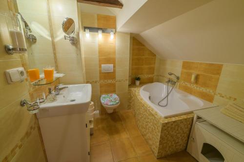 a bathroom with a sink and a tub and a toilet at Penzion U Zámku in Mělník