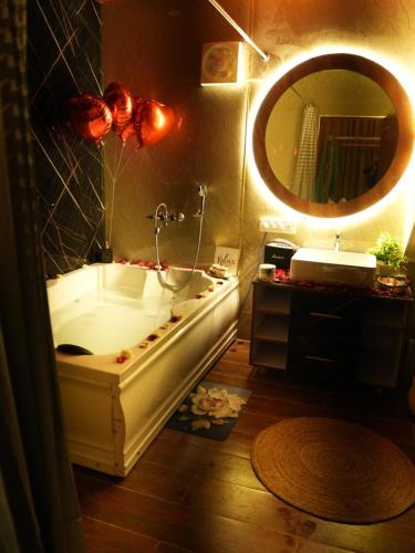 a bathroom with a tub and a large mirror at Dyson Ville in Dehradun