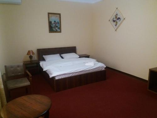 a bedroom with a bed and a table in it at Гостевой дом Barakat in Samarkand