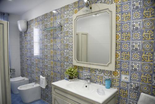 a bathroom with a sink and a mirror at La Laura di Paestum - case vacanze in Capaccio-Paestum