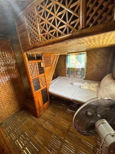 a small room with a bed and a fan at Alta-Cabana in El Nido