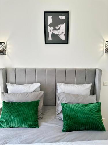 a bed with two green pillows in a bedroom at Appartement moderne entier Paris-le Bourget et CDG in Le Bourget