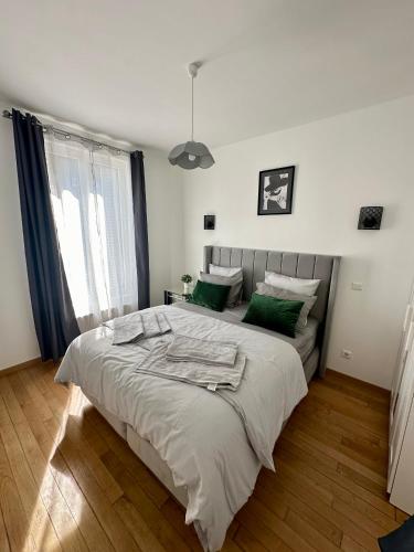 a bedroom with a large bed with green pillows at Appartement moderne entier Paris-le Bourget et CDG in Le Bourget