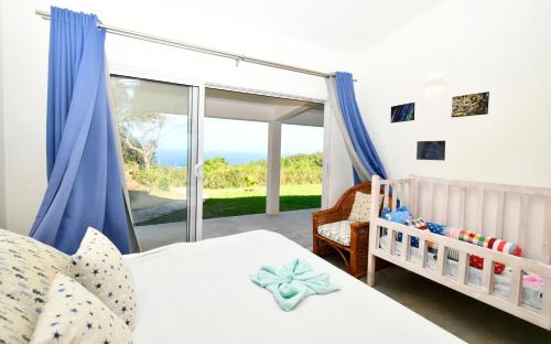 a bedroom with a bed and a baby crib at Zi Limon in Rodrigues Island