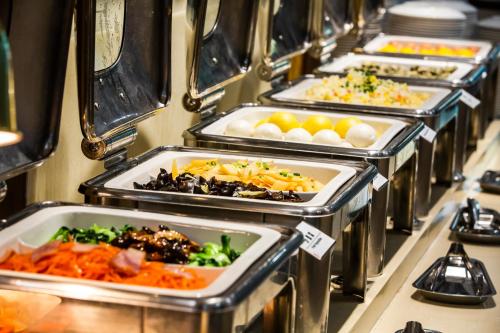 a row of trays filled with different types of food at Zhong An Hotel Beijing Former Residence of Journalist Edgar Snow -Free laundry service,Free freshly ground coffee,Provide tourism and ticketing service ,English service ,Near Tian'AnMen Forbidden City,Wangfujing walking street in Beijing