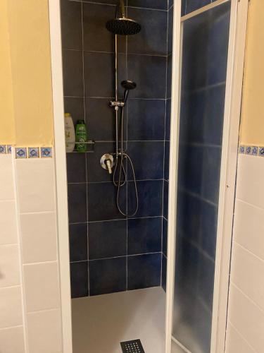 a shower in a bathroom with a blue tiled wall at Musetta sicilian hospitality in Milazzo