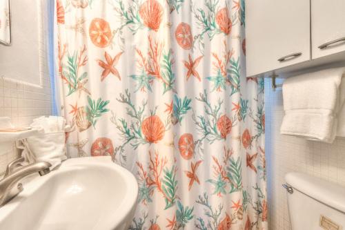 a bathroom with a shower curtain and a sink at Tropic Terrace Suite #24 - Beachfront Resort in St Pete Beach