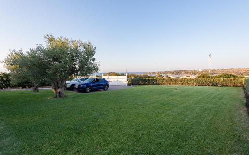 a car parked in a yard with a green lawn at VENTO DI GISIRA in Brucoli