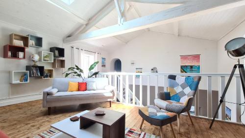 un salon avec un canapé et une chaise dans l'établissement La Maison du Bord du Lac, à La Chevrolière